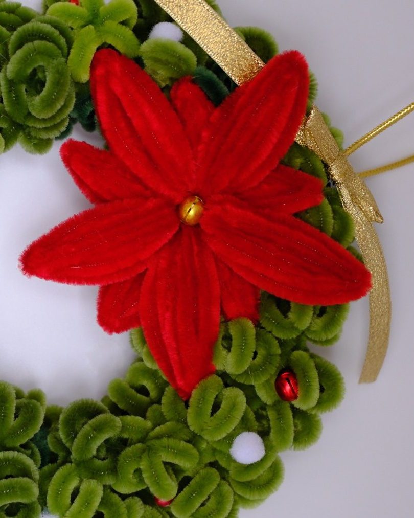 Roter Chenille-Weihnachtsstern mit goldener Glocke in der Mitte